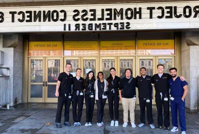 Group of student volunteers in front of Bill Graham Civic Auditorium under a marquee reading Project Homeless Connect 82